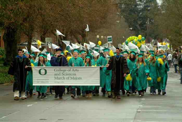 Men and women hold a banner and march in a parade