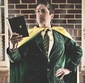 A professor wearing a cape and reading a book in a superhero pose