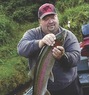 A man holding a caught fish outdoors