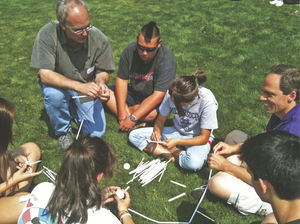 A professor talks with students outdoors