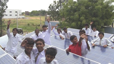 Students celebrate near solar panel grids