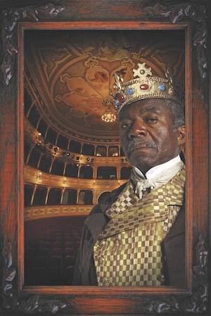Man wearing crown and king's clothes in theater hall
