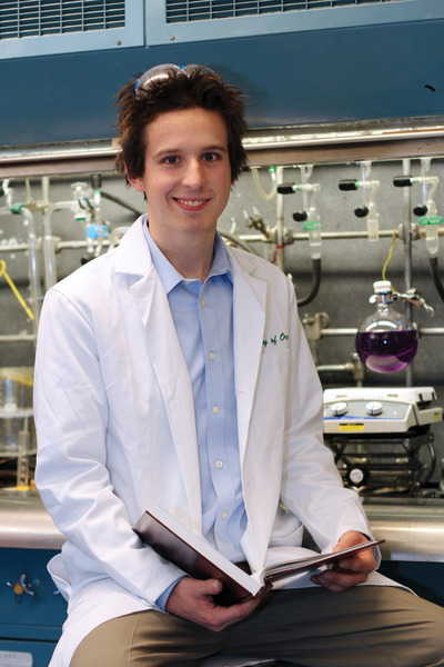 Young man wearing white lab coat in science laboratory