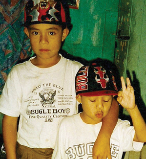 Two young boys wearing matching sports caps