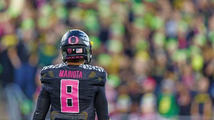 Ducks quarterback Marcus Mariota stands on the football field facing fans