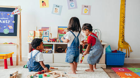 Three children play in a playroom