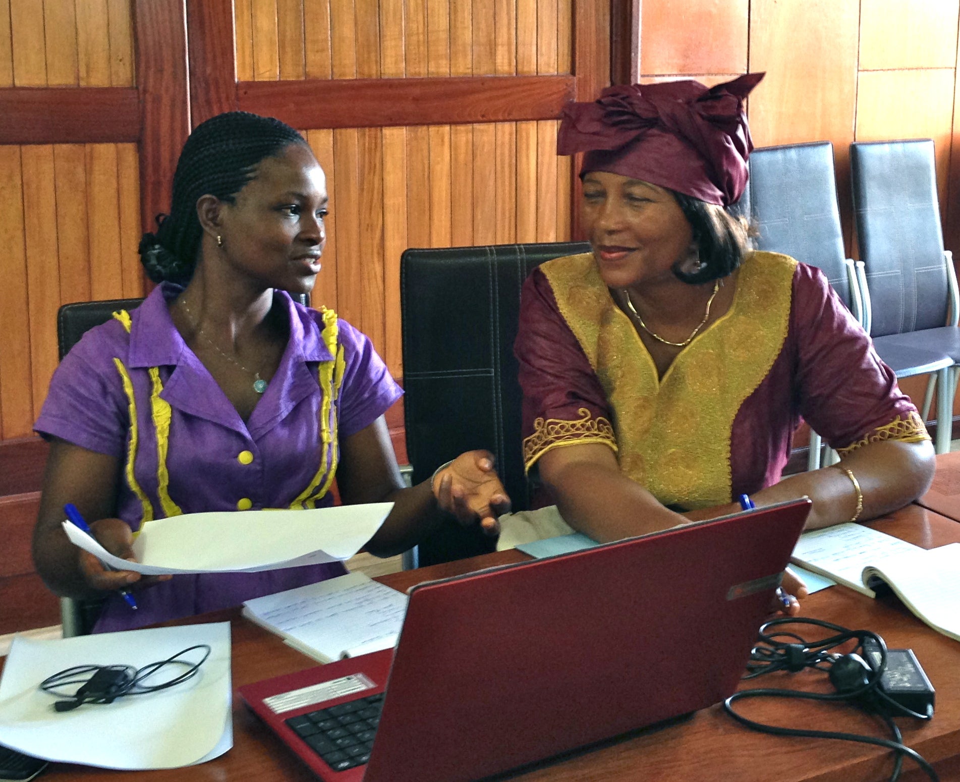 Cameroon: Two women discussing in front of a laptop.