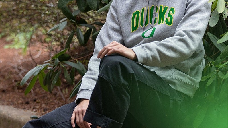 male student wearing a gray UO sweatshirt