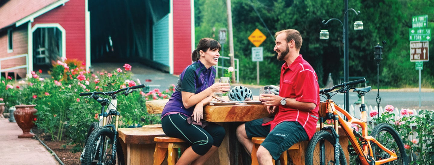 Bikers enjoying a meal near a bridge.