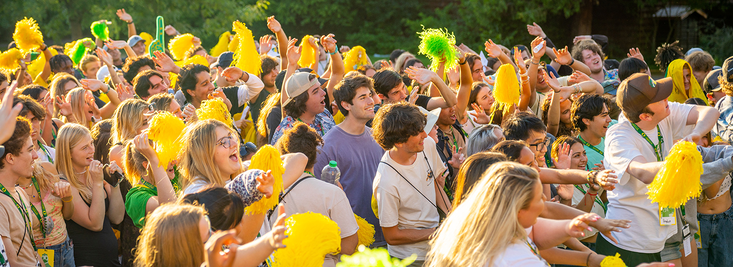 Smiling group of incoming students with pom-poms
