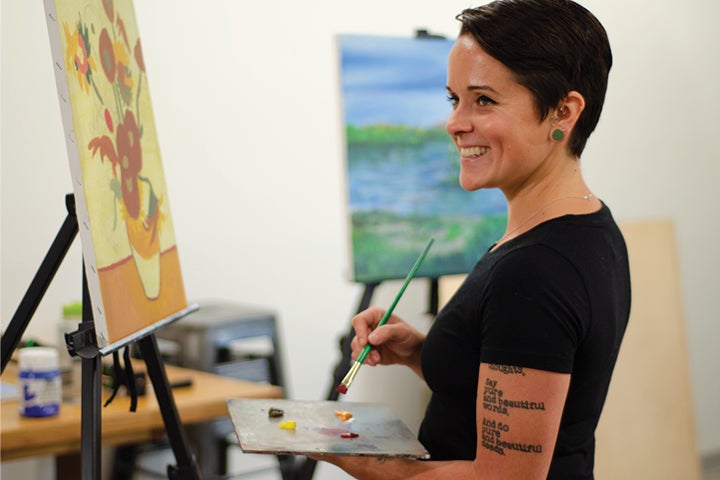 Student painting on canvas.