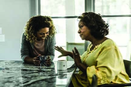 Two African-American women speaking to each other over coffee