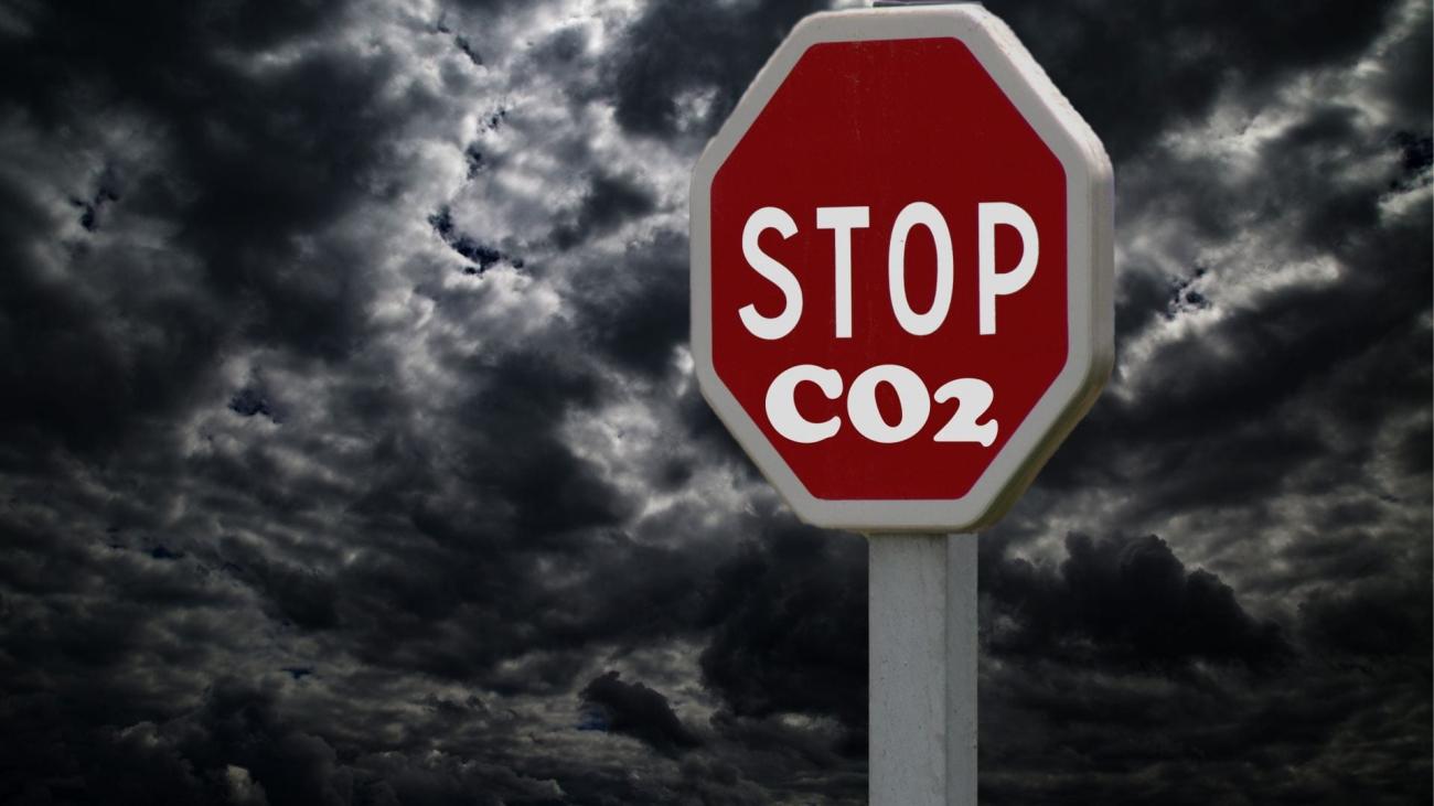 A stock image of a gloomy sky with a stop sign that has "CO2" written below it.