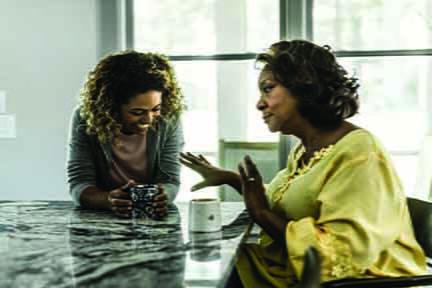 Two women sit at a table talking.