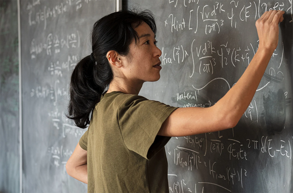 Tien-Tien Yu writing on a blackboard.