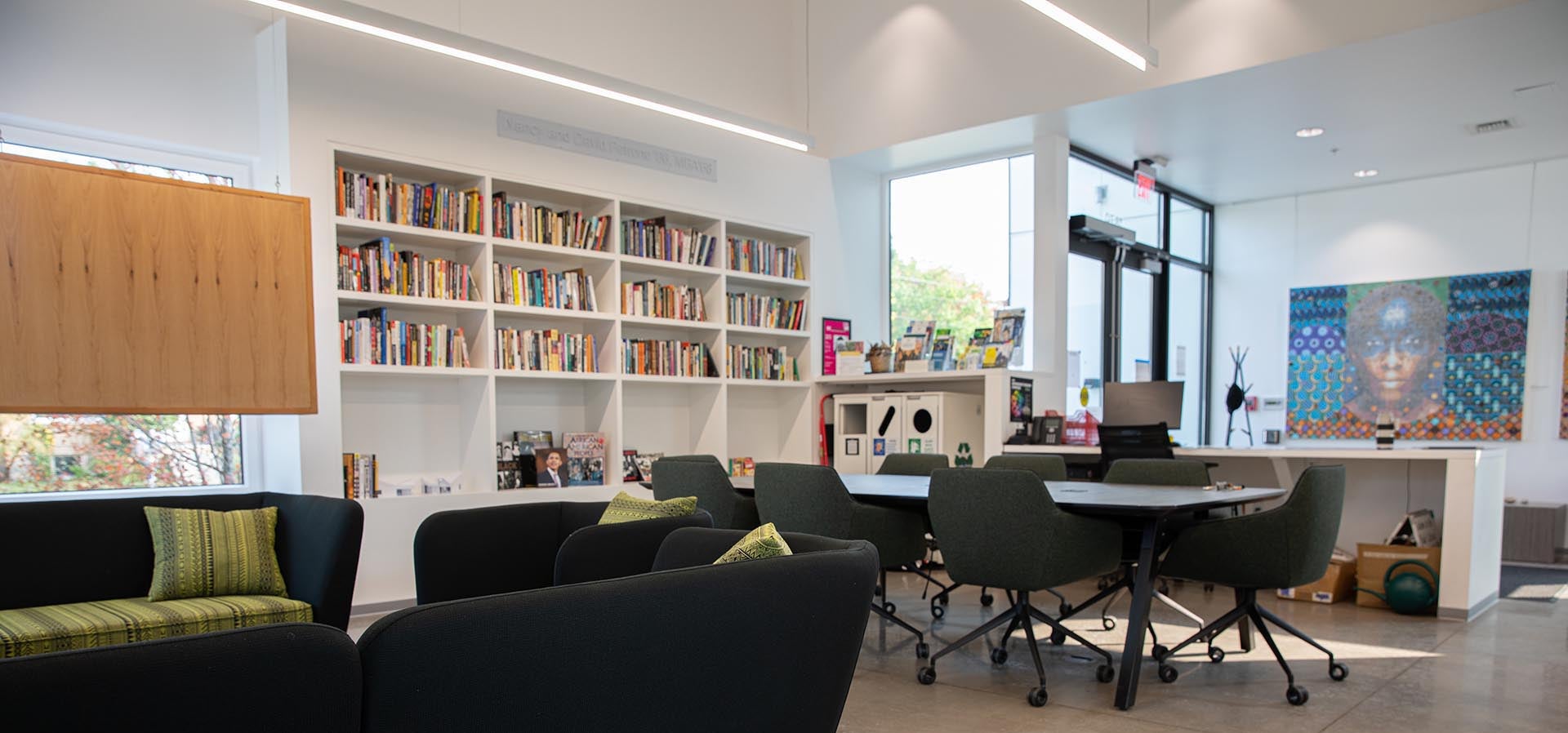 Black Cultural Center room with bookshelves, lounge couches, and meeting table.