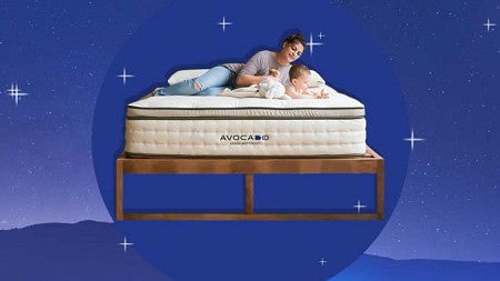 A person relaxes on a white mattress that is resting on a wooden bed frame. The mattress and frame are the foreground to a dreamy, blue background featuring the silhouette of a mountain range, the silhouette of the moon, and several stylized stars. 