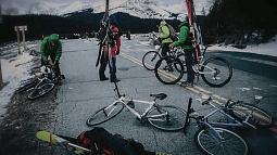 A group of cyclists stop to prepare for a ski trip