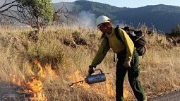 Aja Conrad, the Karuk Tribe’s workforce and internships coordinator, lights a prescribed fire in Orleans, California. Jenny Staats, CC BY-ND