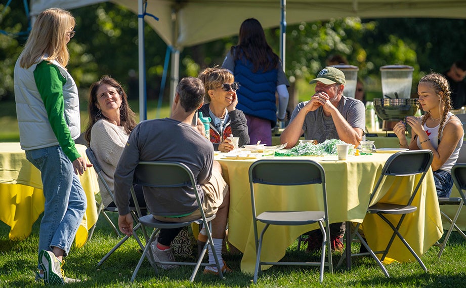 Families sit outside during Fall Family Weekend