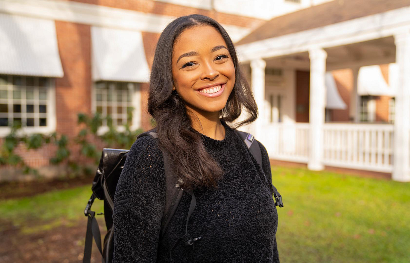 student posing outside with a smile