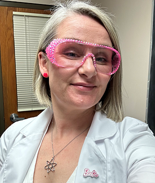 Women in pink safety goggles and lab coat