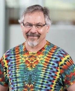 Man with glasses in tie-dye shirt