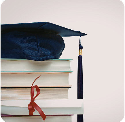 A graduation cap resting on a stack of books