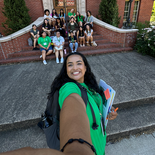 SAIL participants in Latinx program pose for a selfie in front of school building.