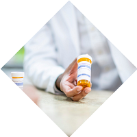 Person in lab coat holding prescription medication bottle