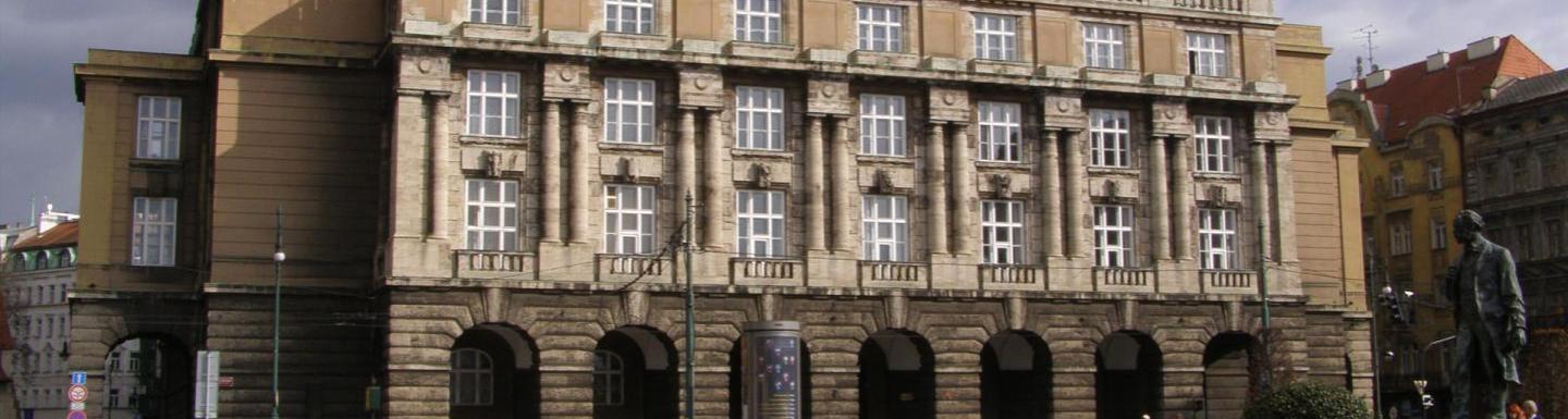 Historic stone university building building with arched entrances and tall windows.