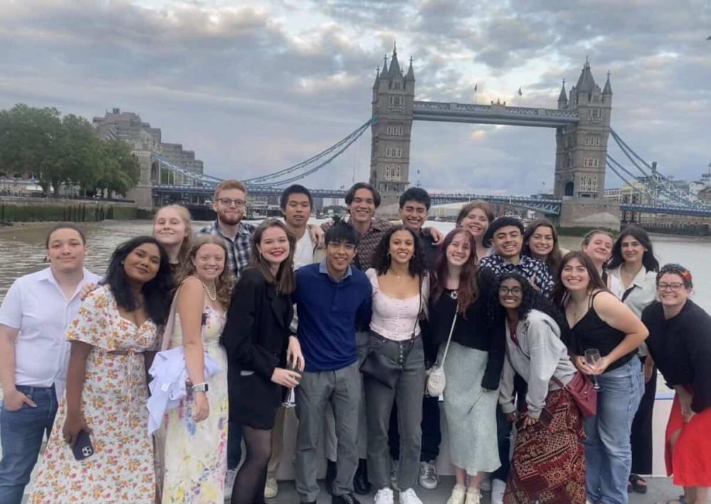Cohort of GEO students smiling on a boat cruise along the river Thames