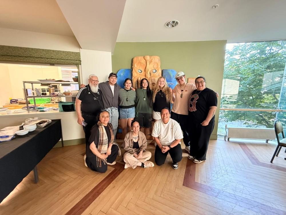 10 people stand together for a picture indoors