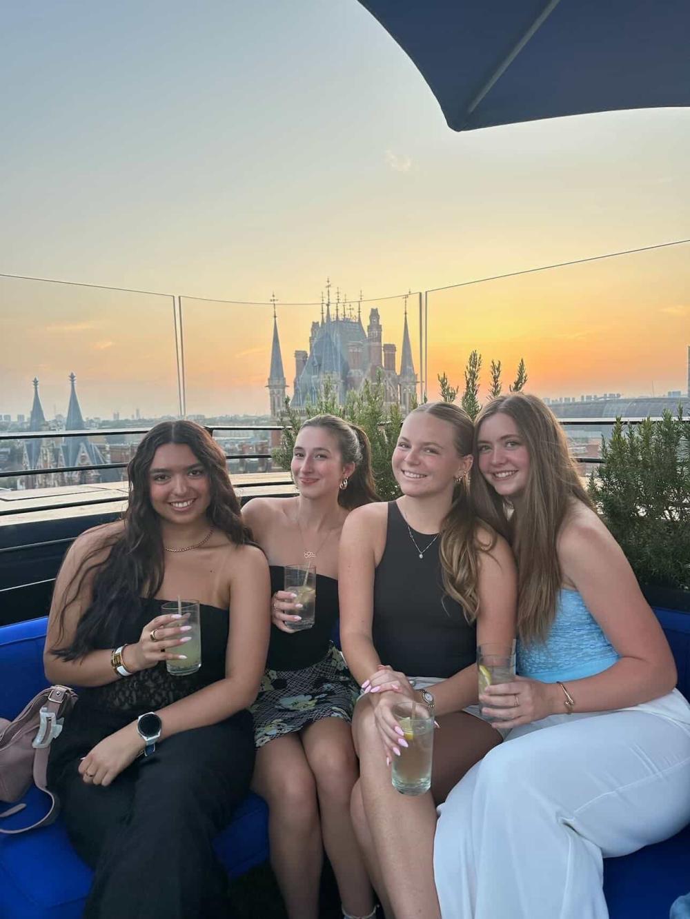Four students at a rooftop bar during sunset in London