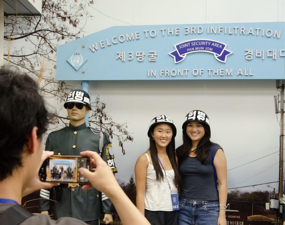 two people stand in front of a sign that reads "Welcome to the 3rd infiltration"