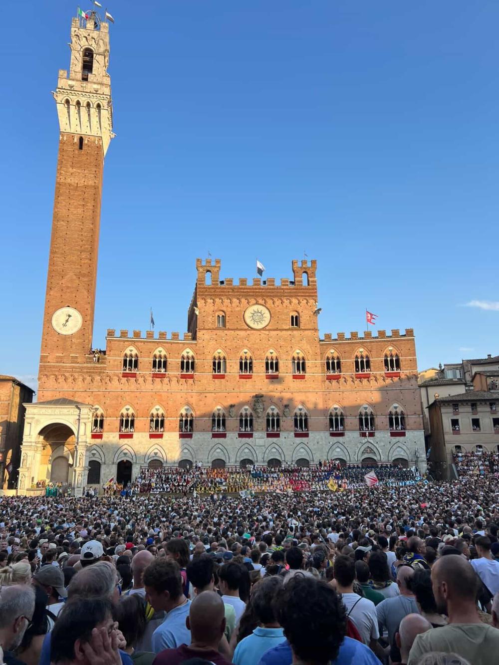 Busy street in Siena with crowds celebrating an event
