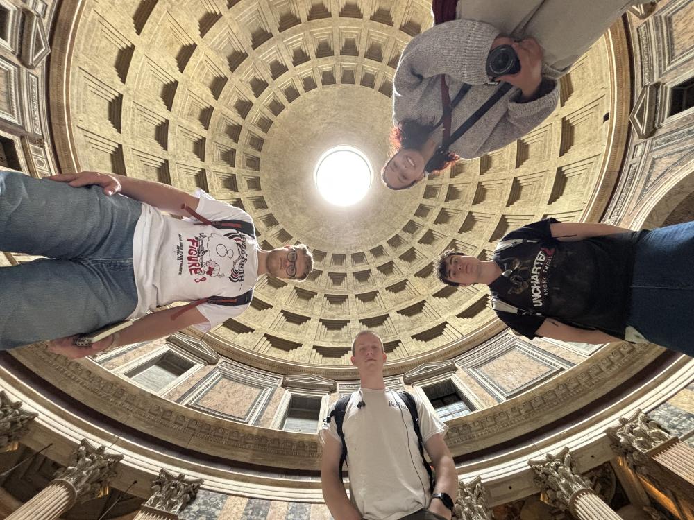 Low angle photo of 4 college students in a Roman cathedral