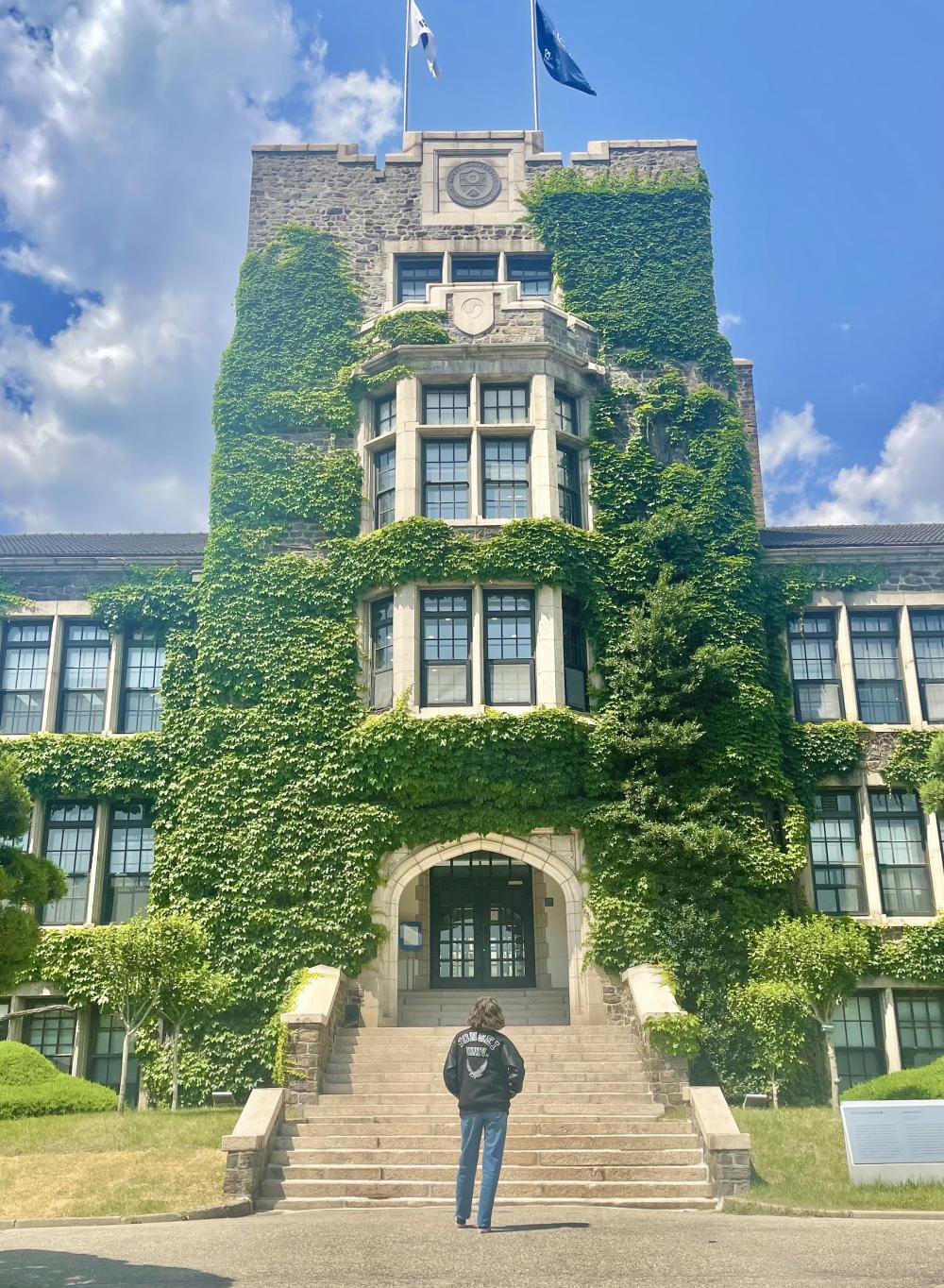 college student standing in front of the entrance to Yonsei University in South Korea