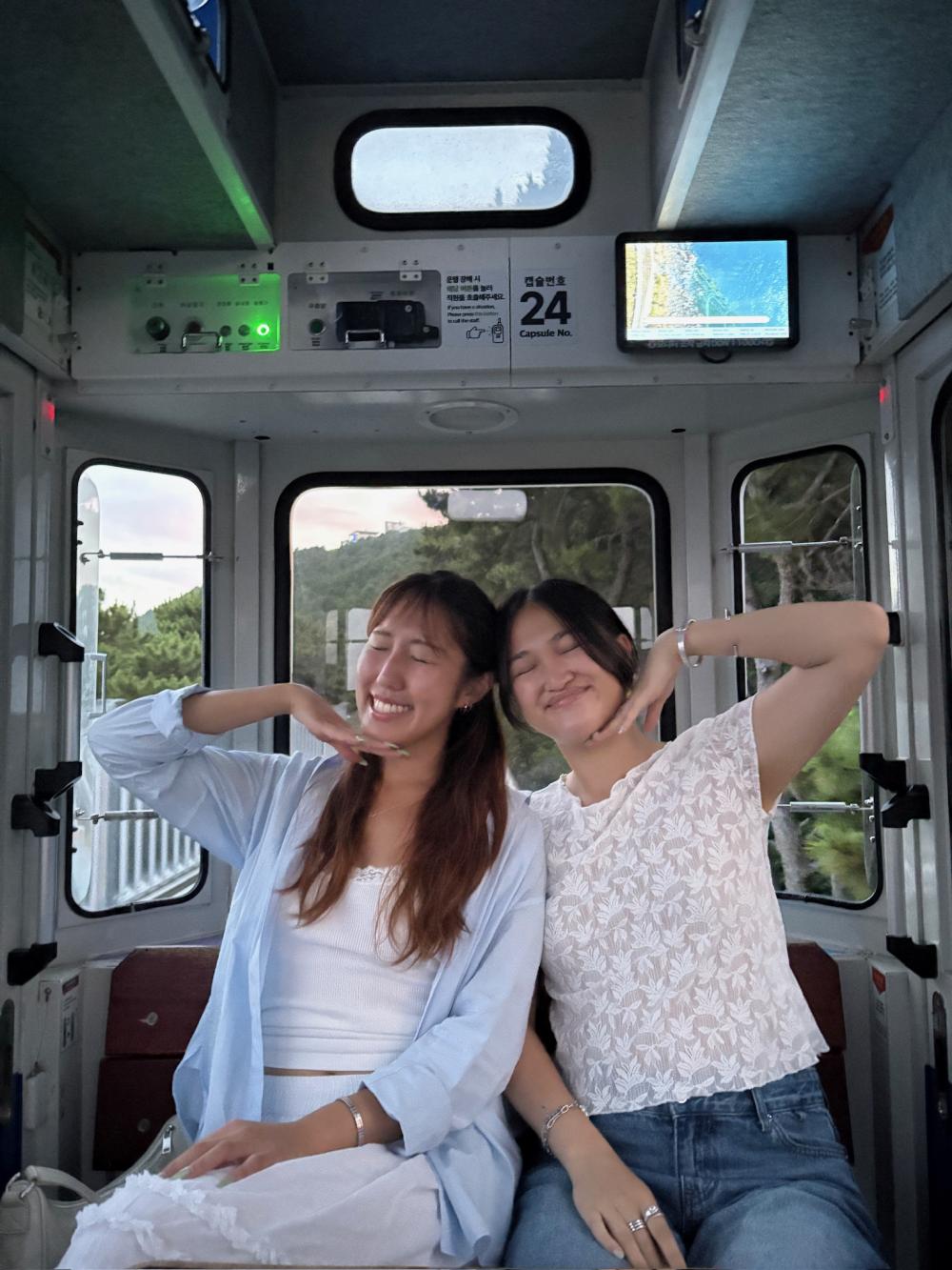Two people pose in a capsule car