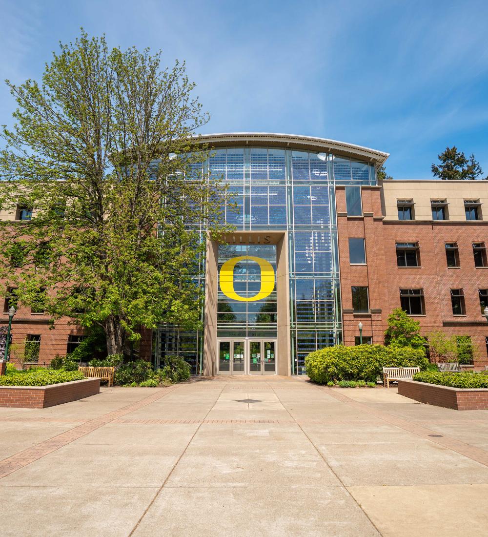 brick building with large glass windows and a large yellow O above the doors