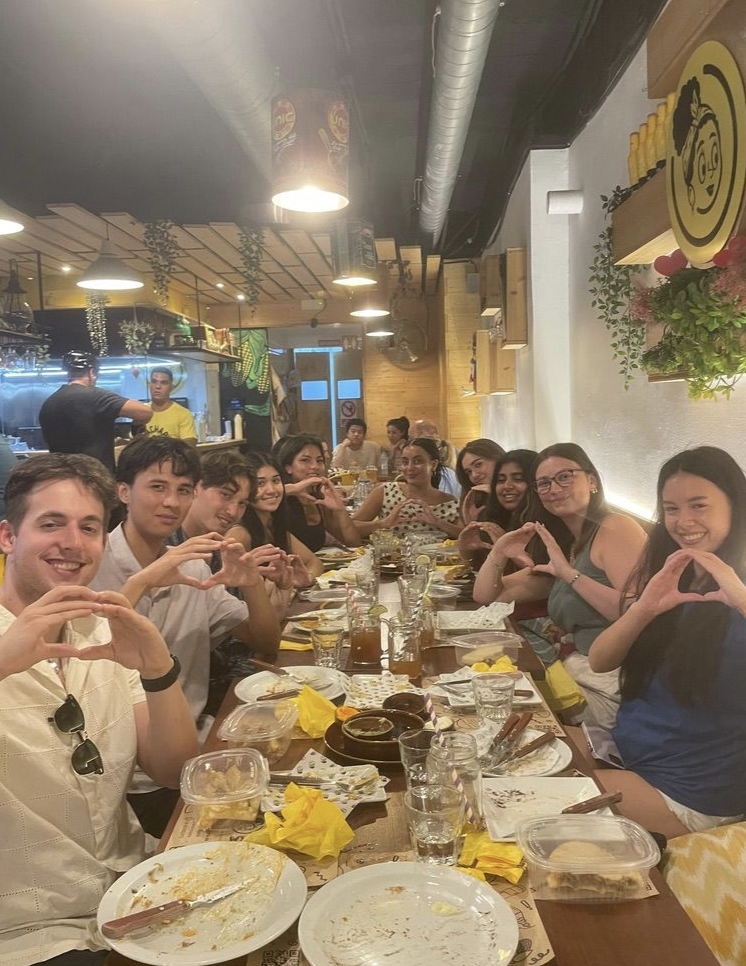 A long rectangular table in a restaurant with approximately 10 people on either side throwing their "O"
