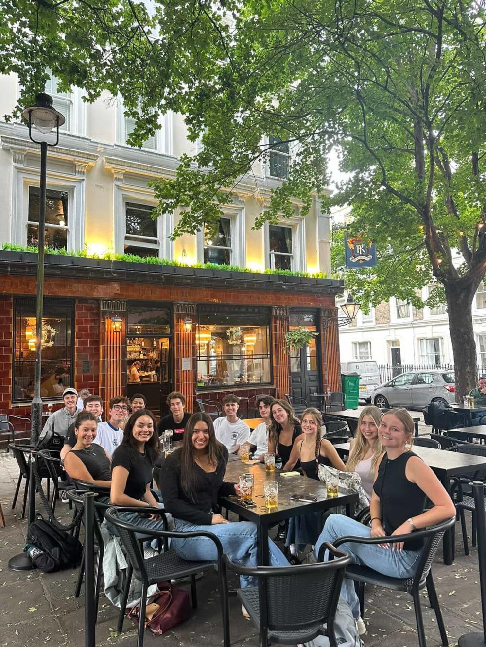 Cohort of GEO students sitting outside of a pub on a evening in London