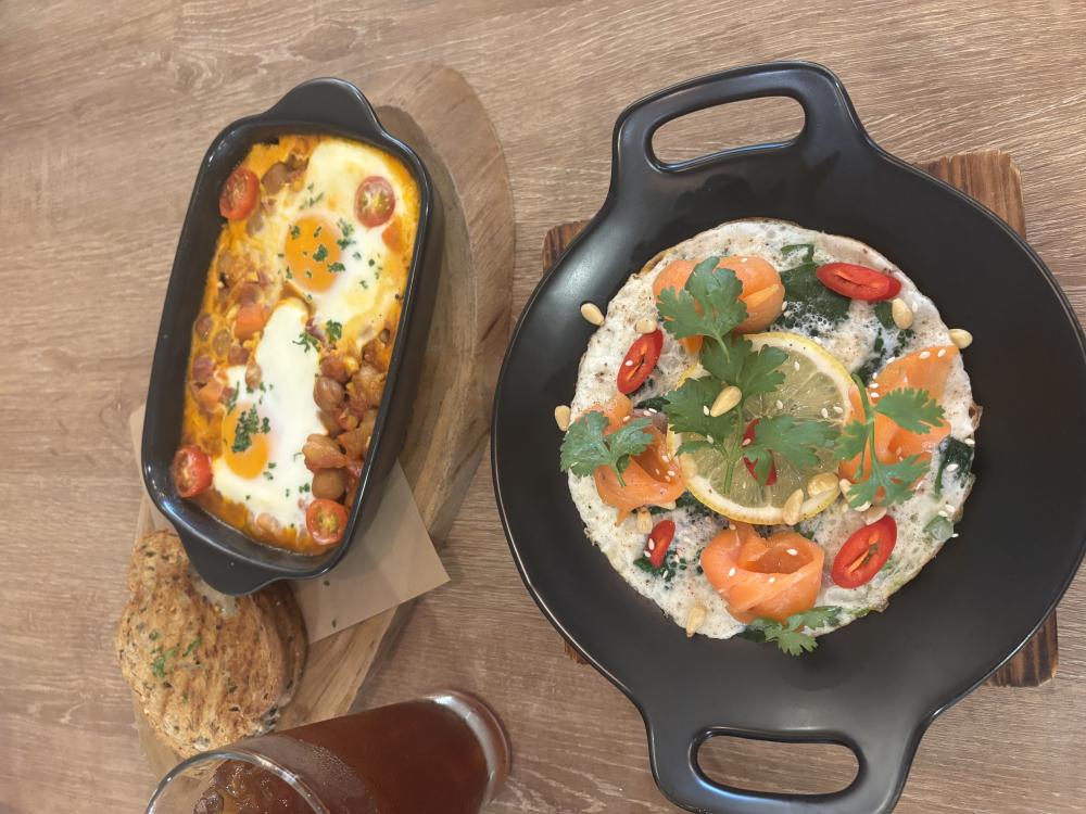 Two food dishes, one with eggs on top, and another with fish