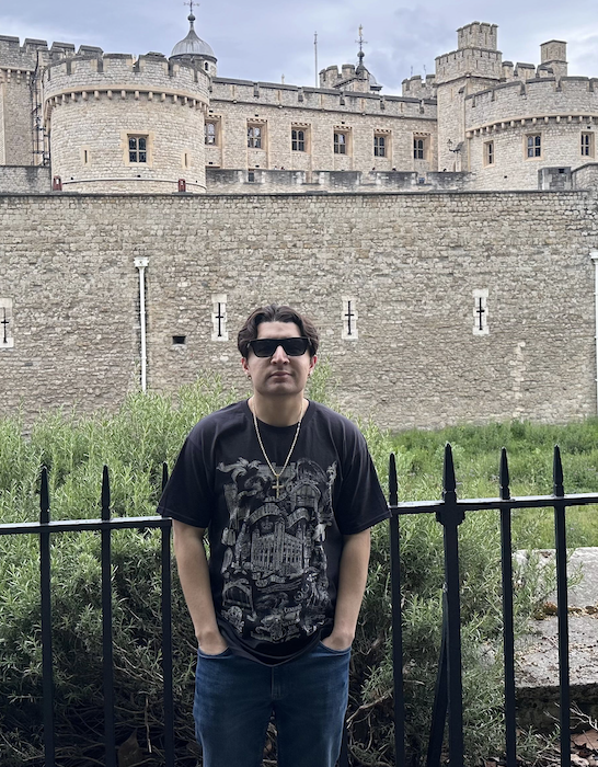 Isaiah standing in front of the Tower of London wearing sunglasses