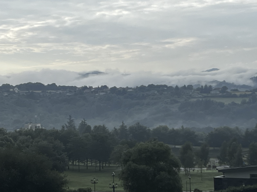 A cloudy landscape of rolling hills and trees in Oviedo