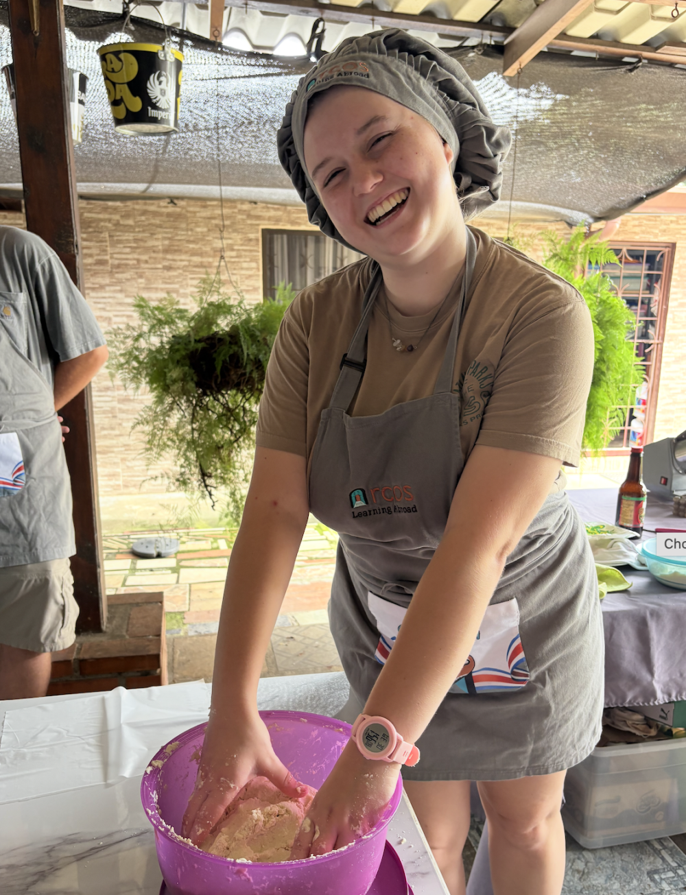 Lane wears a chef hat and mixes tortilla dough in a purple bowl