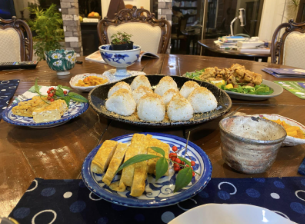 plates of various Japanese dishes, including onigiri at the centerpiece