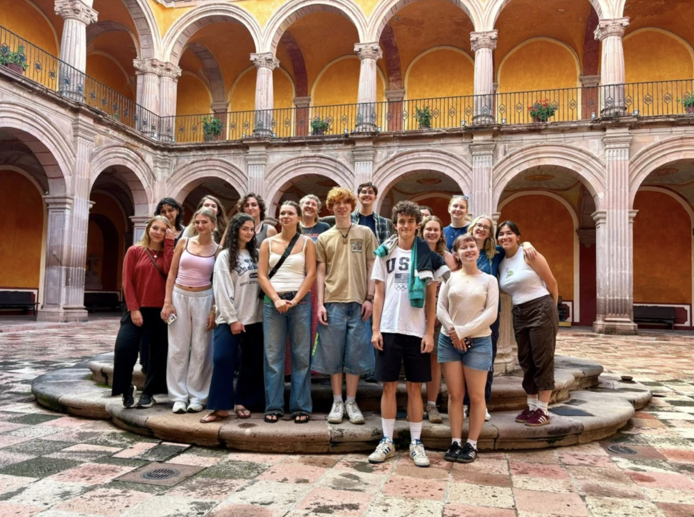 a group of students stand together in a courtyard
