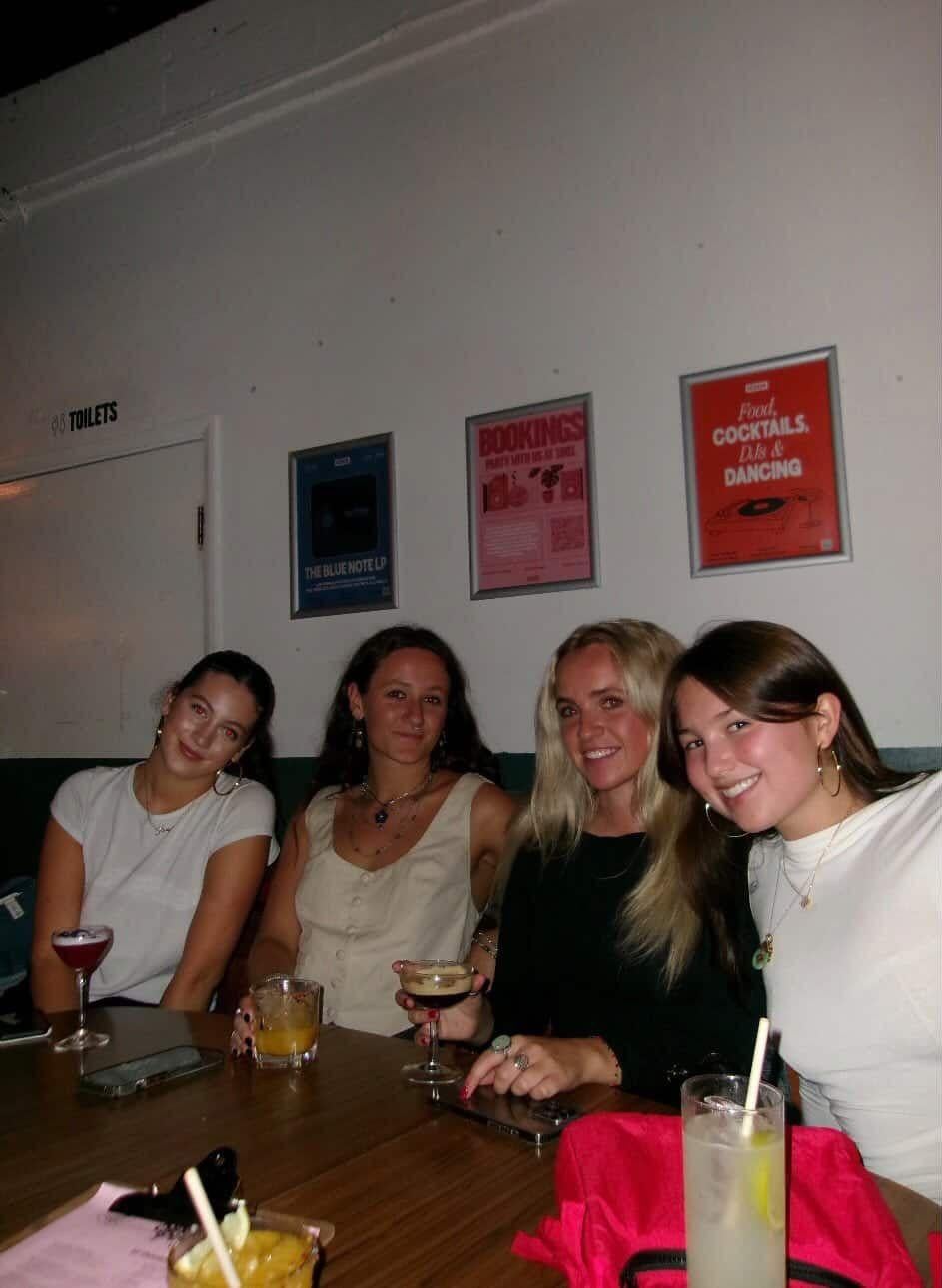 Four students smiling at a bar in Europe