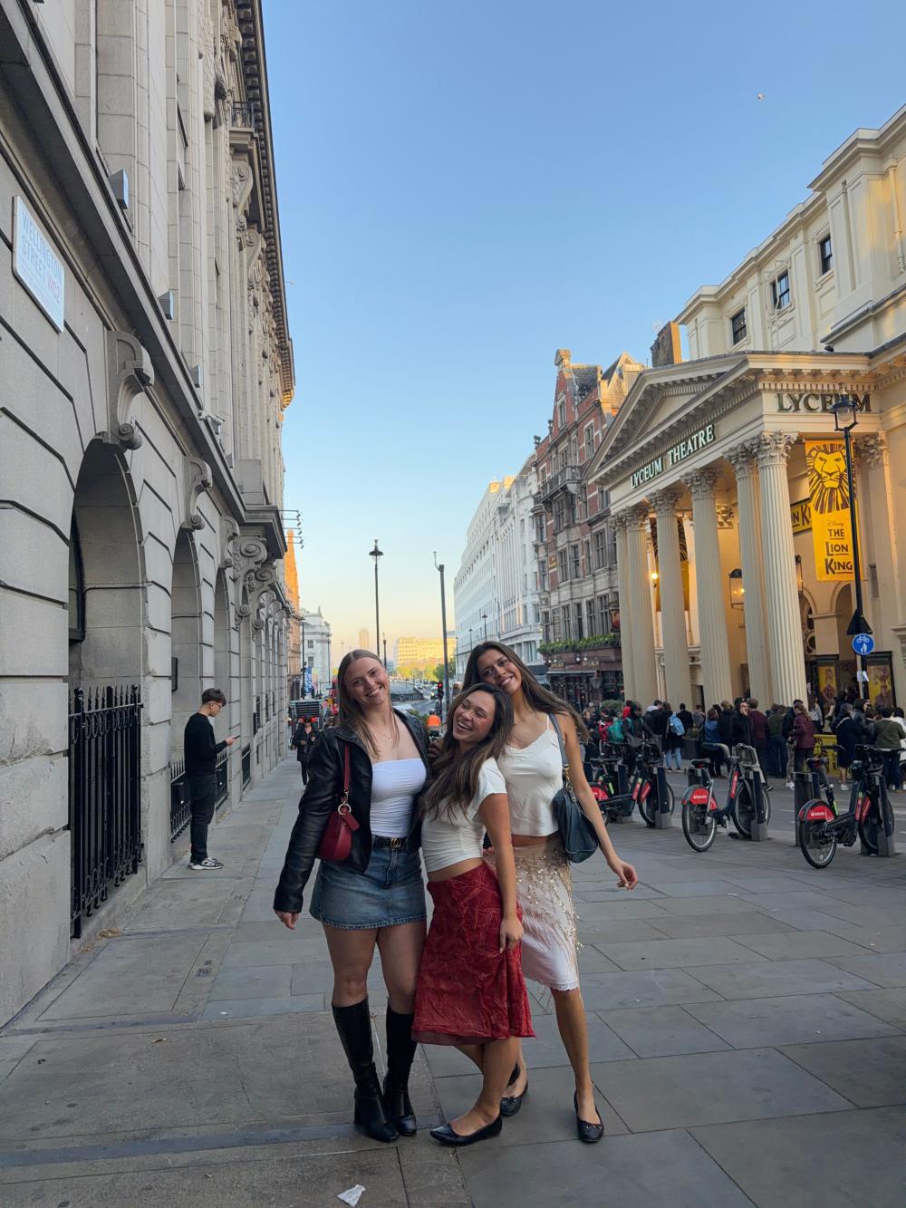 Hana with two friends smiling during a night out in the theatre district of London